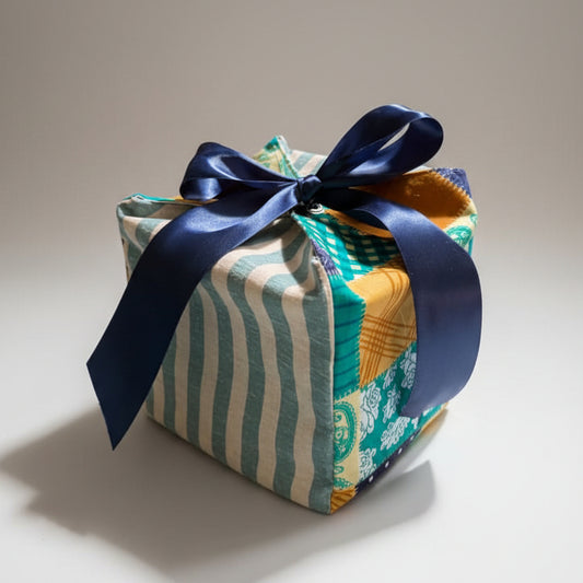 Reusable fabric gift box in a patchwork & striped cotton fabric with a ribbon closure.