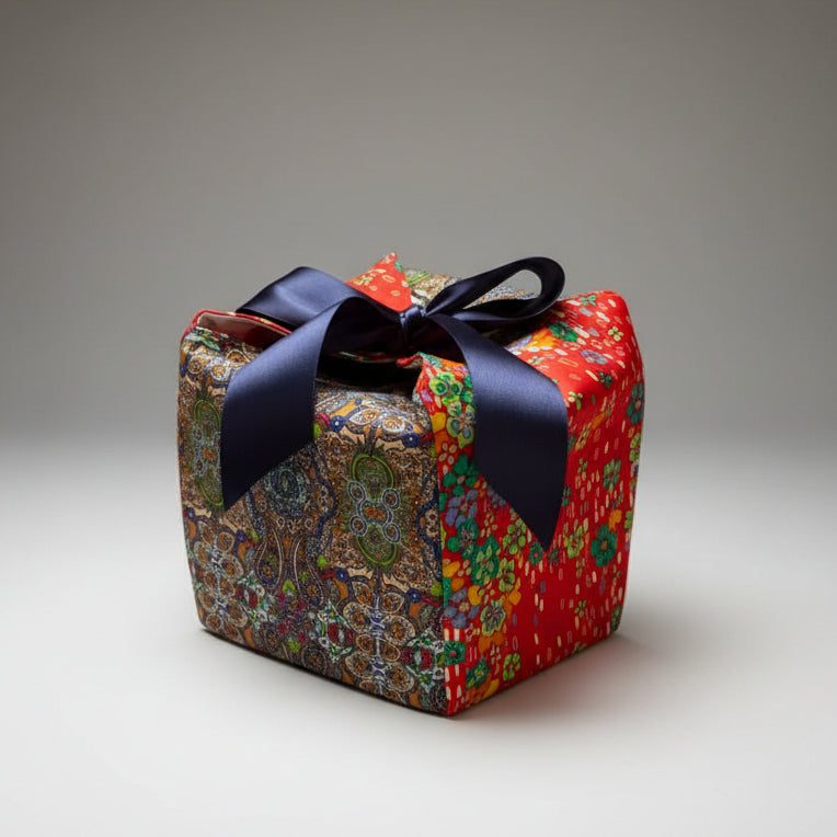 Red & blue bold printed fabric gift box with a blue ribbon closure in 7X7X7 square size.