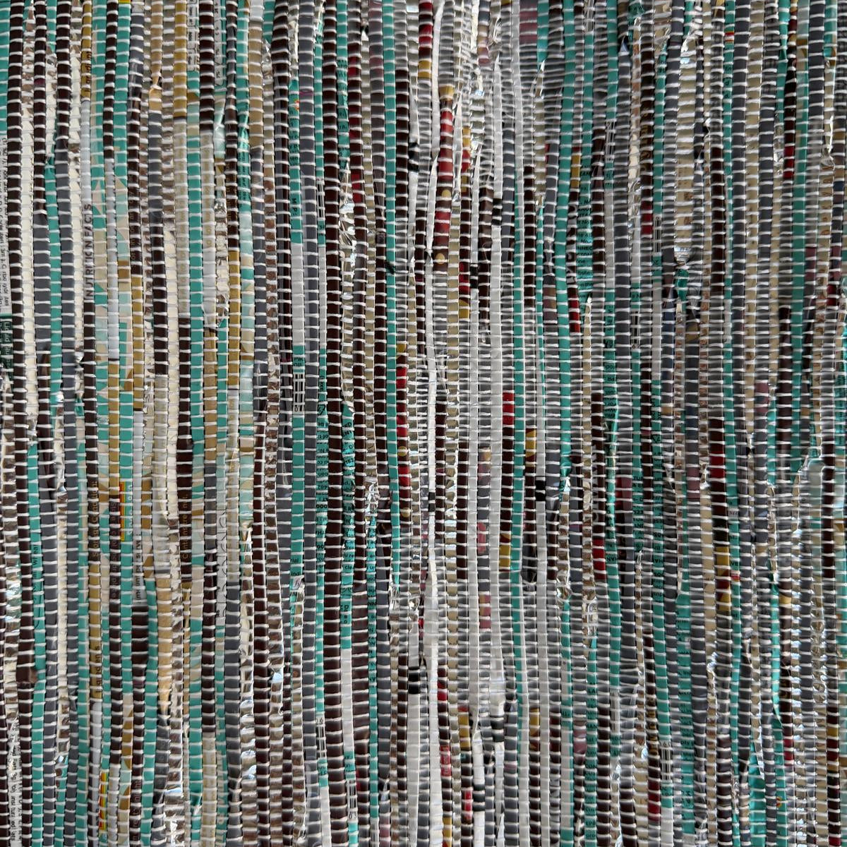 Close-up of upcycled handwoven Sling-It Bag in a teal weave with a black strap.