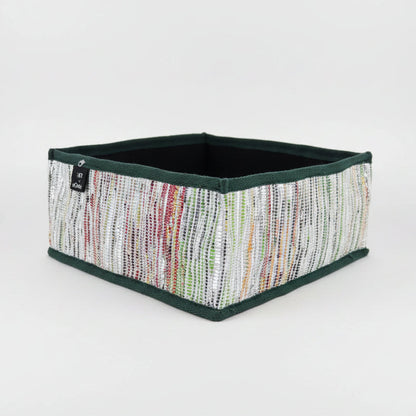 Collapsible storage box in multicolored weave with a dark green trim.