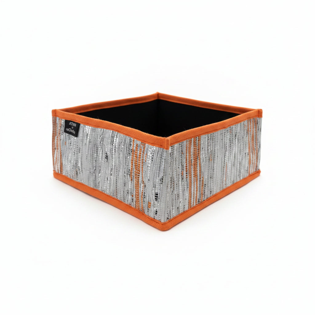 Collapsible storage box small with an orange trim with silver and orange weave.