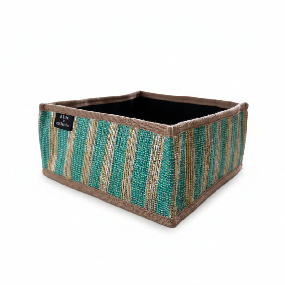Upcycled handwoven collapsible storage basket with green and gold stripes with a beige trim.
