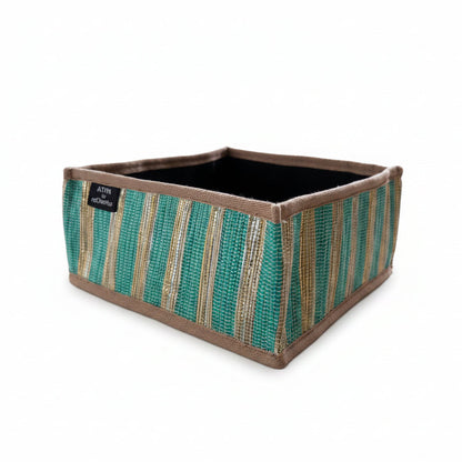 Upcycled handwoven collapsible storage basket with green and gold stripes with a beige trim.