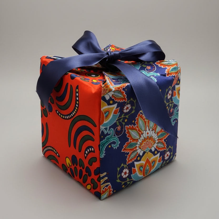 Eco-friendly gift box in a bold African print, in orange & blue with a ribbon closure.