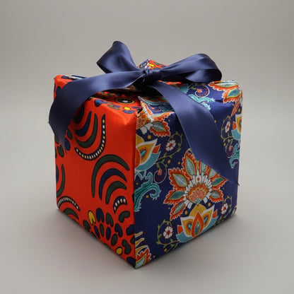 Eco-friendly gift box in a bold African print, in orange & blue with a ribbon closure.