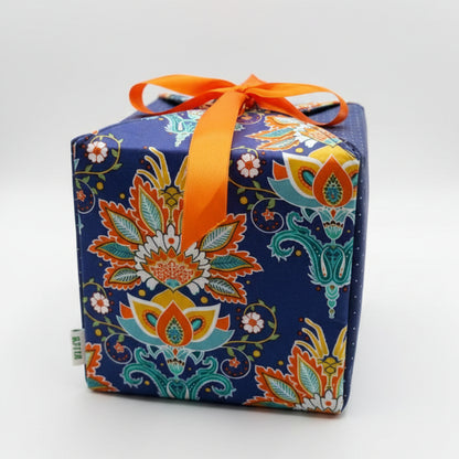 Reusable gift wrap in a bold African print, in orange & blue dots with a ribbon closure.