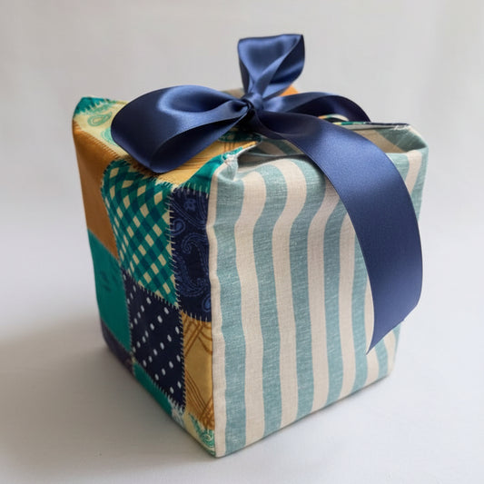 Reusable fabric gift box in a patchwork & striped cotton fabric with a ribbon closure.