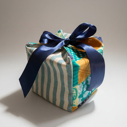 Reusable fabric gift box in a patchwork & striped cotton fabric with a ribbon closure.