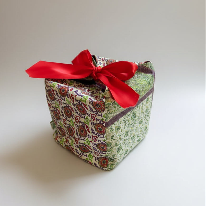 Green & white fabric gift box with a red ribbon closure in 7X7X7 square size.