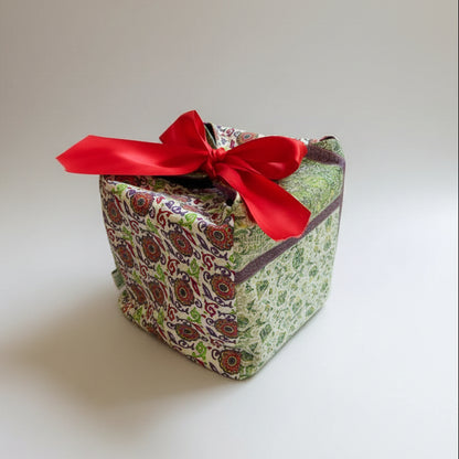 Green & white fabric gift box with a red ribbon closure in 7X7X7 square size.