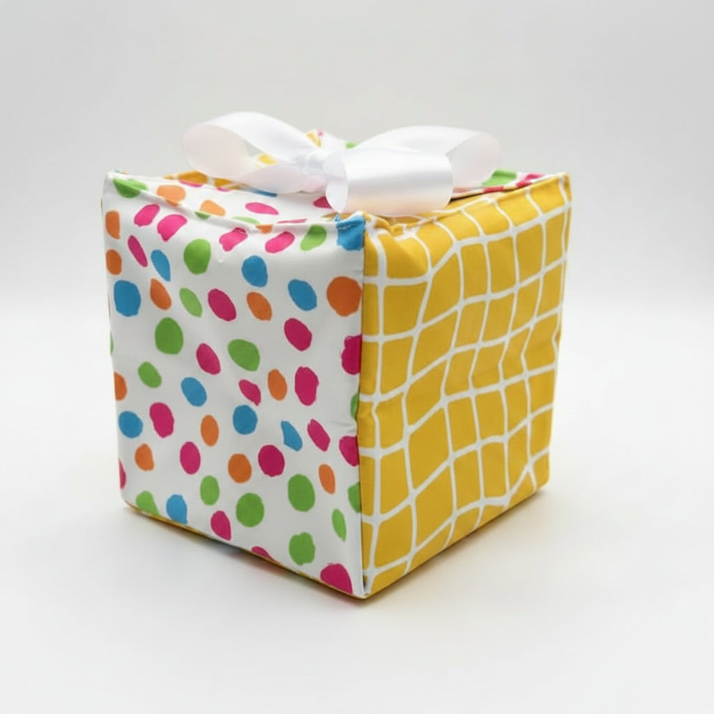 Fabric gift wrap in cotton fabric with multi-color dots & yellow checks, with a ribbon closure.