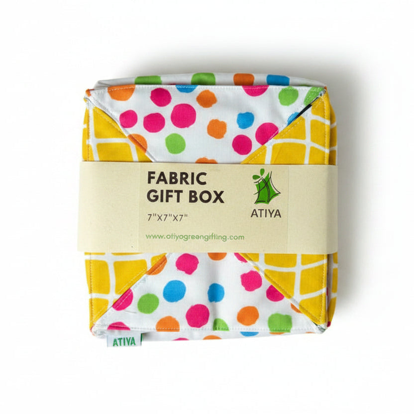 Fabric gift wrap in cotton fabric with multi-color dots & yellow checks, with a ribbon closure.