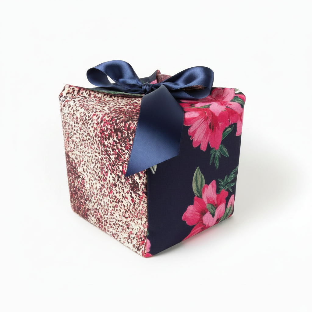 Colorful reusable gift box in pink & blue speckled & floral cotton fabric, with a ribbon closure.