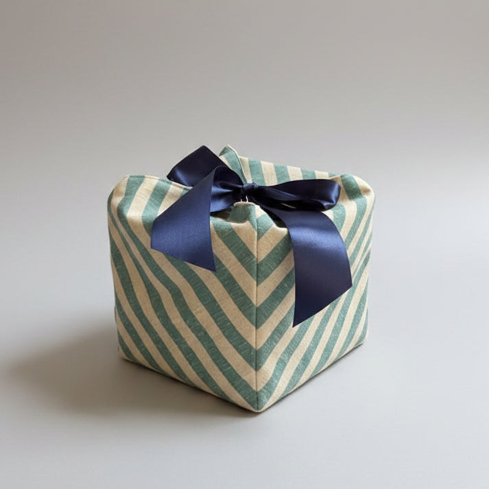 Green & white striped fabric gift box with a blue ribbon closure in 7X7X7 square size.