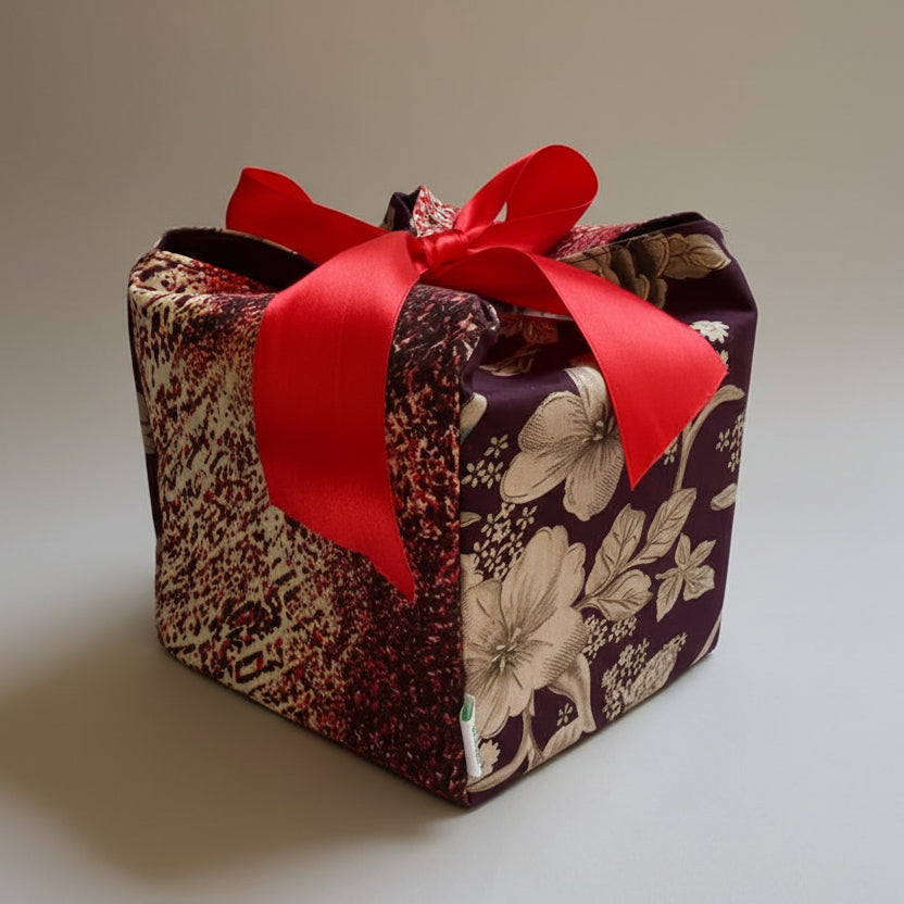 Wine colored floral & speckled fabric gift box with a rede ribbon closure in 7X7X7 square size.