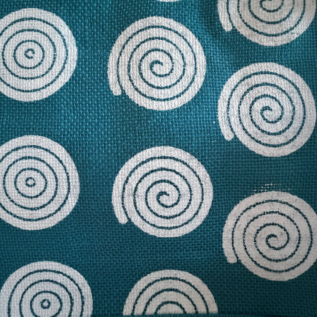 Teal fabric with white spiral patterns