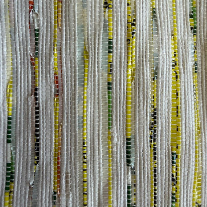 Close-up of upcycled handwoven Messenger Bag in multicolored weave with a dark green strap.