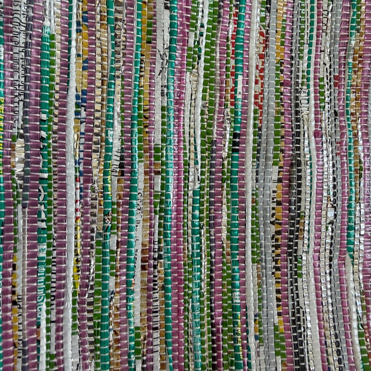 Close-up of upcycled handwoven Messenger Bag in multicolored weave with a black strap.