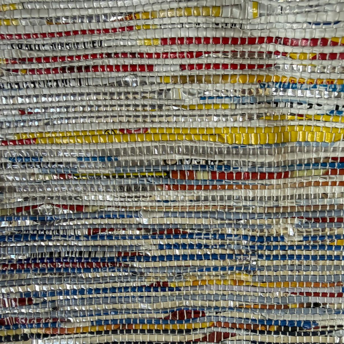 Close-up of upcycled handwoven Messenger Bag in multicolored weave with a navy blue strap.