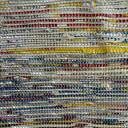Close-up of upcycled handwoven Messenger Bag in multicolored weave with a navy blue strap.