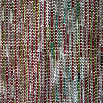 Close-up of upcycled handwoven Sling-It Bag in multicolored pink weave with a navy grey strap.
