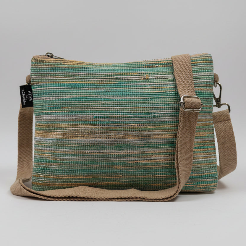 Upcycled handwoven Sling-It Bag in teal and gold weave with a beige strap.