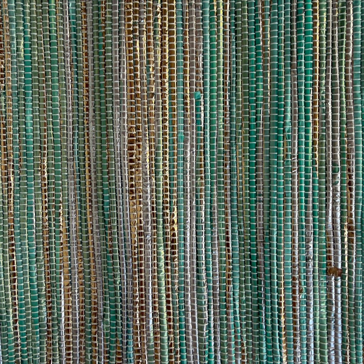 Close-up of upcycled handwoven Sling-It Bag in teal and gold weave with a navy beige strap.