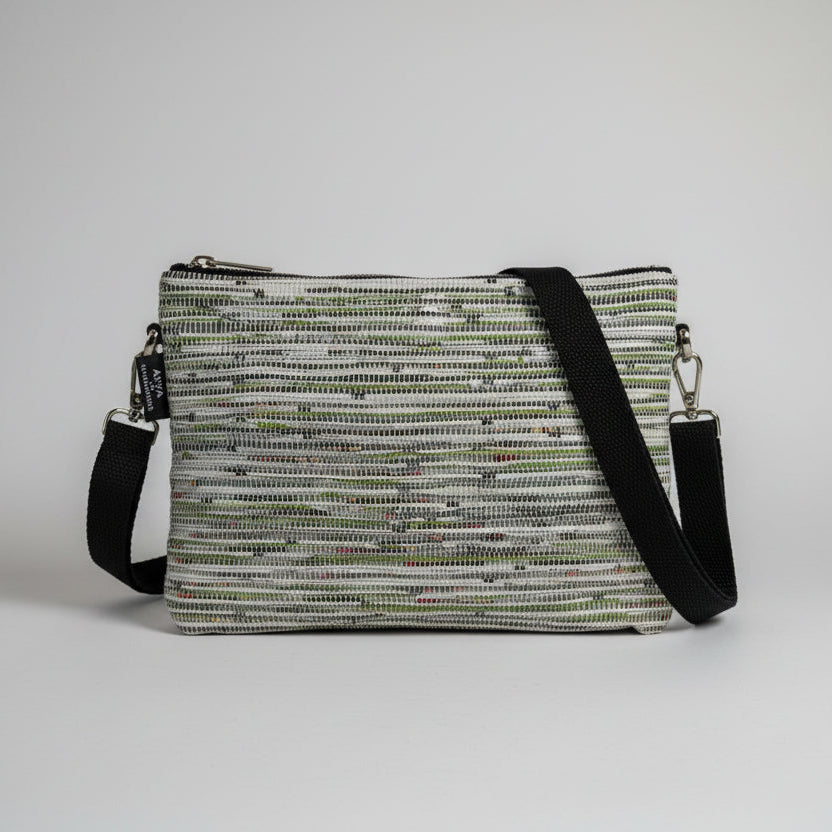 Upcycled handwoven Sling-It Bag in a green and white weave with a black strap.