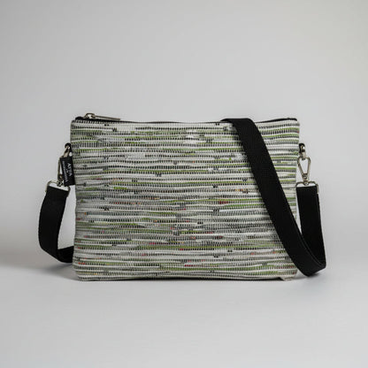 Upcycled handwoven Sling-It Bag in a green and white weave with a black strap.