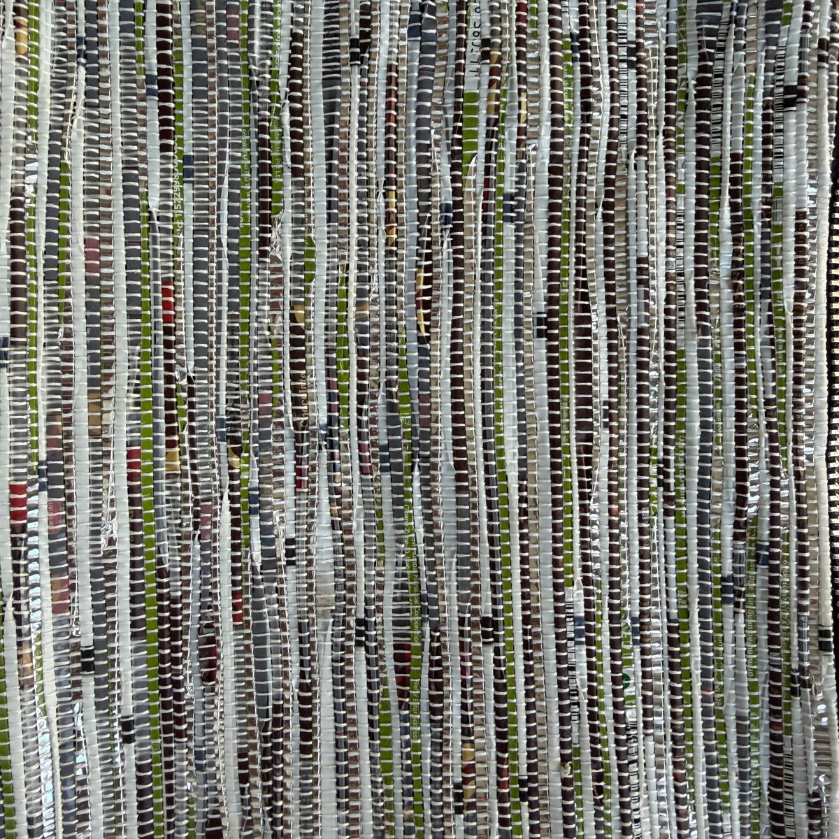 Close-up of upcycled handwoven Sling-It Bag in green and white weave with a navy black strap.