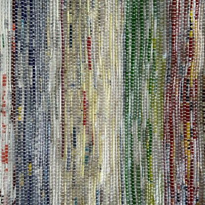 Close-up of upcycled handwoven Sling-It Bag in multicolored weave with a grey strap.