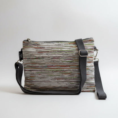 Upcycled handwoven Sling-It Bag in multicolored silver weave with a grey strap.