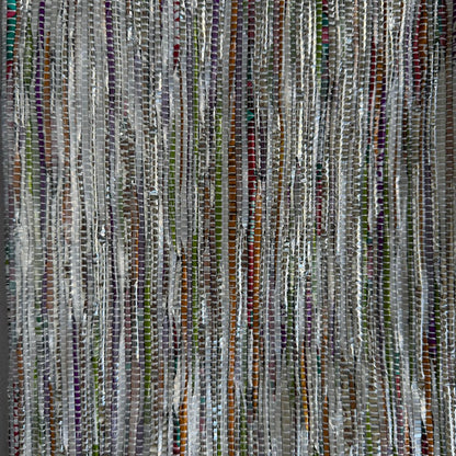 Close-up of upcycled handwoven Sling-It Bag in multicolored silver weave with a grey strap.