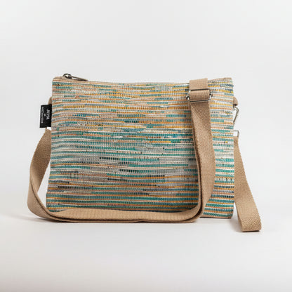 Upcycled handwoven Sling-It Bag in a teal and yellow colored weave with a beige strap.