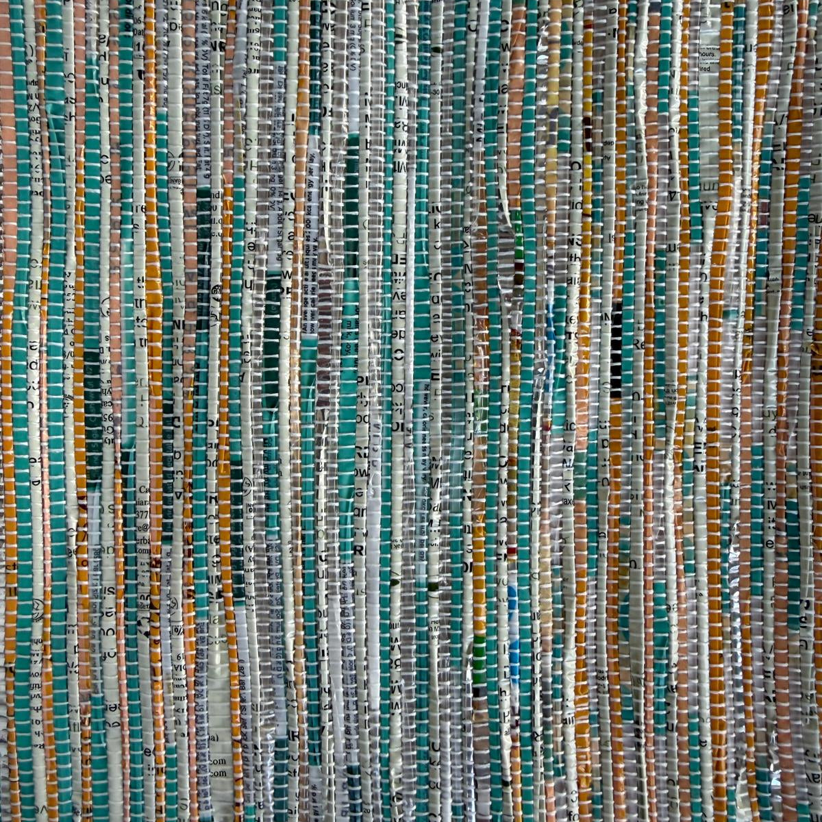 Close-up of upcycled handwoven Sling-It Bag in teal and yellow weave with a beige strap.