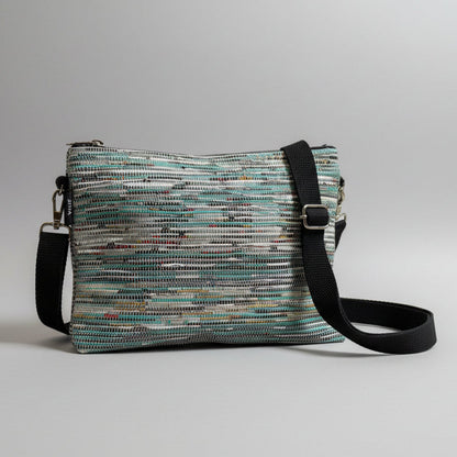 Upcycled handwoven Sling-It Bag in teal colored weave with a black strap.