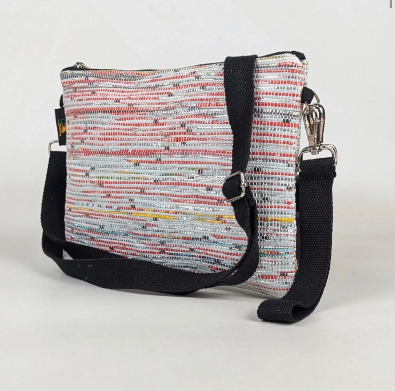 Side view of a multicolored Sling-It bag with a black strap.