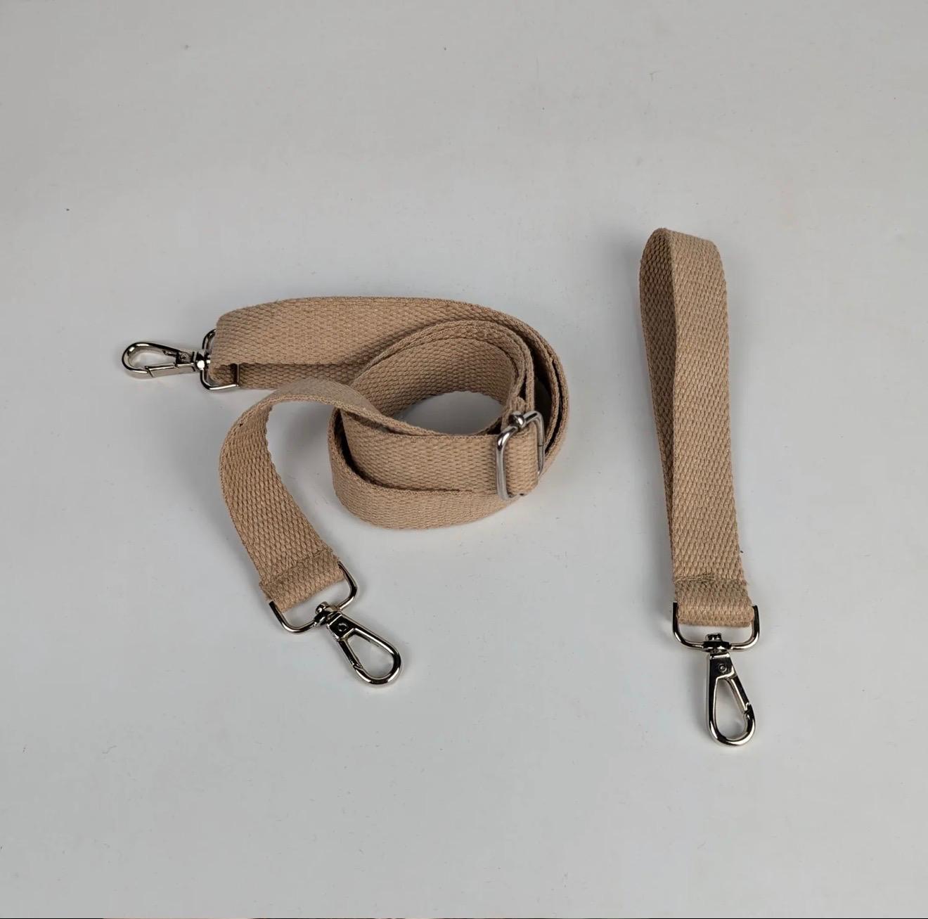 Beige straps with metal clasps which are part of the upcycled handwoven Sling-It Bag.