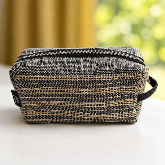 Upcycled handwoven travel pouch in black with thin gold stripes and a side loop for easy grab and go.