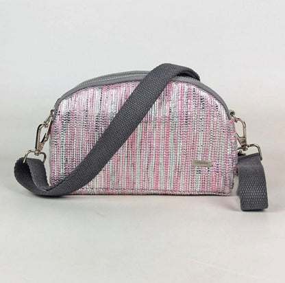 Pink and gray Taco Sling crossbody bag with a studio background.