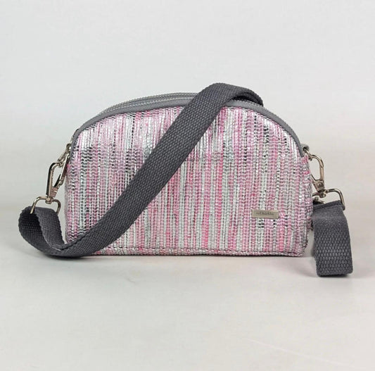 Pink and gray Taco Sling crossbody bag with a studio background.